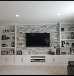 a living room with built in shelves and a flat screen tv mounted on the wall