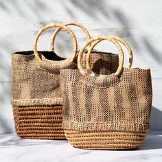 Gorgeously woven, this palm fiber handbag is truly one-of-a-kind. Made from locally sourced palm, this environmentally friendly handbag features fabric a cotton lining with small pockets within to keep your essentials organized! Palm fiber & cotton Lined handbag 1 interior zipper pocket 2 interior open pockets Small: 8" H x 10" L x 3.75" D (20.3 x 25.4 x 9.5 cm) Large: 10" H x 12" L x 3.5" D (25.4 x 30.5 x 8.8 cm) Handmade in & fairly-traded from Bangladesh Eco-friendly Rectangular Natural Shoulder Bag, Brown Jute Bag With Bamboo Handle, Eco-friendly Woven Bucket Bag With Top Handle, Handwoven Rectangular Bucket Bag In Natural Fiber, Natural Bucket Bag With Braided Handles For Market, Natural Bags With Leather Handles For Market, Natural Straw Bag With Double Handle For Market, Palm Leaf Bucket Bag For Market, Natural Bags With Leather Handles