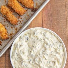 chicken tenders with ranch dip in a bowl on a baking sheet next to the tray