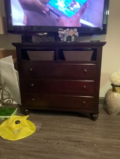 a flat screen tv sitting on top of a wooden dresser