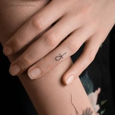 a woman's hand with a small tattoo on it