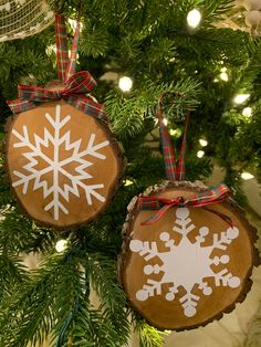 two wooden ornaments hanging from a christmas tree