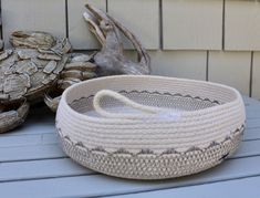 a white basket sitting on top of a wooden table