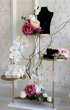 three tiered display stands with flowers on them