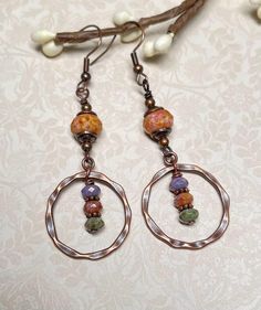 Boho earrings with rustic vibes.  These were created using small Czech Picasso rondelles in shades of green, terra cotta, and amethyst, a larger Czech rondelle in terra cotta, copper bead caps and spacers, and antique copper hammered connector hoops. For matching necklace, click on the link below: https://www.etsy.com/listing/1782426537/czech-glass-beaded-boho-necklace-with?click_key=82ee792fcb60d7941c87300d97fa47d6024c8247%3A1782426537&click_sum=53adc9de&ref=shop_home_active_2&pro=1 Total lengt Beaded Boho Necklace, Marvel Dr, Eyeliner Makeup, Earring Designs, Earring Ideas, Dope Jewelry, Fall Earrings, Earrings Bohemian, Rustic Boho