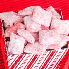 there is a red and white striped bowl filled with sugar cubes