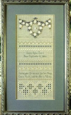 a cross stitch pattern in a frame with flowers on the bottom and an ornate border