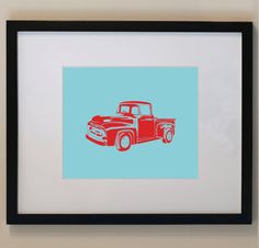 an old red truck on a blue background framed in a black frame hanging on the wall