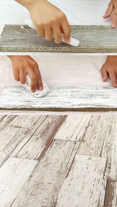 someone using a mouse to clean the wood planks on a floor that has been painted white