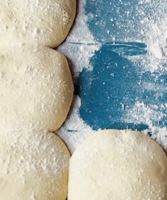 doughnuts are lined up on a table with powdered sugar scattered around them