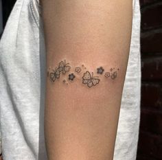 a woman's arm with butterflies and stars tattoo on the back of her left arm