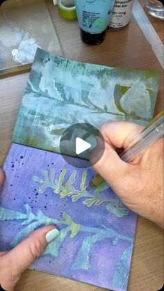 a person is painting with acrylic paint on paper and then using a marker