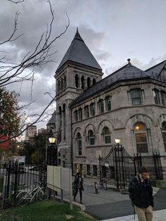 two people are walking in front of an old building