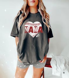 Step up to the plate in style with our 'Baseball Mom Shirt'! Designed for the trendy and proud baseball mama, this cute and fashionable tee is the perfect outfit for game day. Whether you're cheering from the bleachers or supporting your little leaguer from the sidelines, our shirt lets you do it with flair. Crafted with comfort in mind, our tee features a stylish design that's perfect for any sports-loving mom. You can show off your team spirit with your child's jersey number prominently displayed, making it a personalized top that's as unique as your little player. This Game Day Shirt for Women is more than just apparel; it's a way to celebrate your child's passion for baseball. It's ideal for little league games, school sports events, or simply showing your support during practice sessi Cotton Baseball Jersey With Short Sleeves For Fans, Cotton Short Sleeve Baseball Jersey For Fans, Short Sleeve Baseball Jersey With Letter Print, Fan Apparel Short Sleeve Baseball Jersey With Letter Print, School Spirit Baseball Jersey With Letter Print, School Spirit Baseball Jersey For Baseball Season, Baseball Season T-shirt With Heat Transfer Vinyl, Game Day Baseball Season Graphic Tee, School Spirit Tops With Name Print For Baseball Season