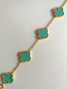 Adorn your wrist in elegance with our exquisite Clover Bracelet. Inspired by the iconic symbol of luck, this bracelet is crafted from the finest gold plating. Elevate any outfit with this sophisticated and exclusive piece, perfect for those with a taste for luxury. Elegant Blue Bangle Charm Bracelet, Elegant Blue Gold-plated Bracelets, Elegant Turquoise Adjustable Charm Bracelet, Elegant Blue Bracelets With Adjustable Chain, Luxury Gold Plated Charm Bracelet, Elegant Blue Metal Chain Bracelet, Green Luxury Metal Jewelry, Elegant Turquoise Chain Bracelet As Gift, Elegant Turquoise Jewelry, Tarnish Resistant