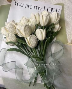 a bouquet of white flowers sitting on top of a table next to a sign that says you are my love