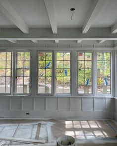 an empty room with three windows and some tape on the floor