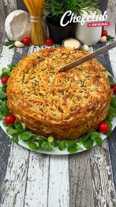 a large pie is on a plate with tomatoes and other food items around the cake