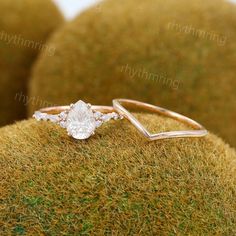 an engagement ring sitting on top of a mossy surface