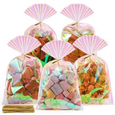 four bags filled with candy and small fan shaped decorations on top of each bag, all in iridescent colors