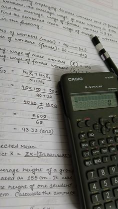 a calculator sitting on top of a piece of paper next to a pen