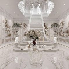 a large foyer with marble floors and white walls, chandelier and flowers on the table