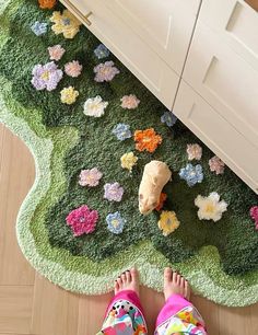 a person standing on the floor next to a rug with flowers