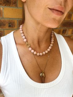 This classic beaded necklace  with toggle clasp is made from genuine Peruvian pink opal (undyed) and gold vermeil findings. It looks great solo or layered with other chains.  MATERIAL Peruvian opal, gold vermeil (18k gold over sterling silver).  SPECIFICATIONS Length: 43 cm (17 inches) Beads measure 10 mm, AAA quality  Handmade in Spain Necklace comes in a gift box Worldwide shipping with registered trackable post Care for gold vermeil jewelry: avoid contact with water and storing in humidity. S Opal Bead Necklace, Pink Opal Beaded Jewelry, Single Strand Pink Opal Necklace With Round Beads, Pink Opal Jewelry With Natural Stones, Gold Vermeil Jewelry, Peruvian Opal, Vermeil Jewelry, Opal Stone, Pink Opal