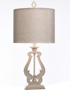 a table lamp with a beige shade on it's base and a white background