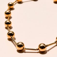 The Golden Ball Choker is a classic neckace with a modern twist. The repetition of the gold ball design is sophisticated. The design of the bars in between the gold balls adds a touch of modern , making this a unique mix of elements. This necklace is made with 18 kt. gold plated pieces and elevates any outfit. 16-18 in. Elegant Gold Plated Necklaces With Ball Chain, Modern Gold Ball Chain Jewelry, Modern Gold Necklace With Beaded Chain, Elegant Gold Plated Ball Chain Jewelry, Elegant Gold-plated Ball Chain Jewelry, Gold Ball Chain Classic Necklace, Modern Gold Jewelry With Polished Beads, Gold Sphere Ball Chain Jewelry, Gold Necklaces With Polished Beads For Everyday