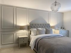 a bedroom with white walls and gray bedding