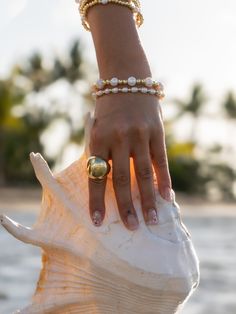 Bold and gold ring! The Beach Sun Ring is an eye-catching 18 karat gold plated, circular shaped ring. It has a puffed appearance, making it very interesting and a statement ring that you will wear day and night.Size: Adjustable Gold Pearl Ring With Metal Band, Elegant Adjustable Rings For Beach, Body Necklace Chain, Sea Siren, Sun Ring, Jewelry Beach, Beach Photoshoot, Saved Items, Cuff Earrings