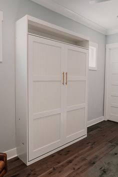 an empty room with white doors and wood floors