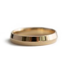 a gold wedding ring on a white background with no one in it's photo