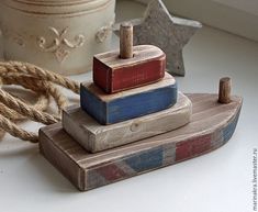 three wooden blocks stacked on top of each other next to a rope and potted plant