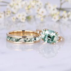 two wedding rings with an emerald colored stone