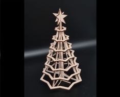 a wooden christmas tree on a black surface