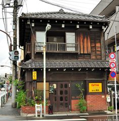 an old wooden building on the corner of a street