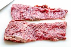 two pieces of raw meat sitting on top of a cutting board