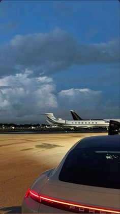 an airplane is taking off from the airport runway with another plane on the tarmac in the background