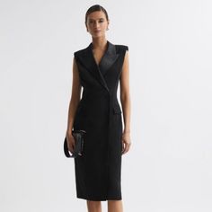 The Black Amari Dress Nods Toward Traditional Menswear Tailoring With Its Confident Double-Breasted Shape, Padded Shoulders, And Four-Button Fastening. It S Given A Feminine Twist With Satin Lapels And A Chic Midi Length, Which Wraps Close Against The Frame. Style Tonally For A Timeless Look. Wrap Design. Double Breasted. Satin Peak Lapels. Padded Shoulders. Sleeveless. Four-Button Fastening. Flap Pockets. Midi Length. Fitted. Lined. The Model Is Wearing A Size 8. Measurements Of Model: Height 5ft 10'' / 178cm. Regular Side Neck To Hem 45.5" / 115cm. Chic V-neck Jacket Dress For Formal Occasions, Tailored Black V-neck Dress, Tailored Elegant Jacket Dress For Party, Elegant Tailored Jacket Dress For Party, Elegant Jacket Dress For Office, Chic Fitted Cocktail Jacket Dress, Elegant V-neck Jacket Dress For Formal Events, Chic Fitted Jacket Dress For Cocktail, Chic Black Midi Business Dress