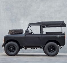 an off - road vehicle is parked in front of a concrete wall