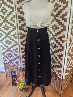 This skirt is a 90s dream! The material of the skirt is like a long john with white flower buttons up the front.  Measures flat in inches: 13.5↔17 30 length Chic Fitted Skirt With Gold Buttons, Fitted Maxi Skirt With Button Closure For Summer, Chic Long Skirt With Buttons, Vintage Black Skirt With Buttons, Chic Maxi Skirt With Buttons For Spring, Chic Spring Maxi Skirt With Buttons, Chic Fitted Maxi Skirt With Buttons, Chic Fitted Maxi Skirt With Button Closure, Fitted Chic Maxi Skirt With Buttons