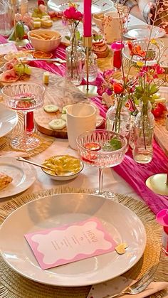 the table is set with pink and white dishes