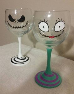 two wine glasses with faces painted on them