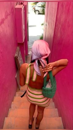 a woman in a colorful dress is walking down the stairs with her back to the camera