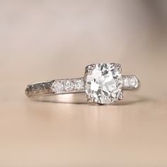 a white gold ring with an oval cut diamond surrounded by three smaller round brilliant diamonds