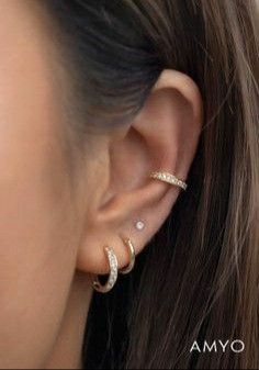 a woman wearing three different types of ear piercings on her left ear and the other half