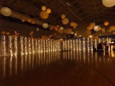 a large room filled with lots of lights and paper lanterns hanging from it's ceiling