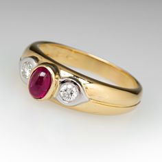 This lovely ring is centered with one (1) oval cabochon cut natural ruby set into a bezel. The shoulders are each accented with one (1), flush set, round brilliant cut diamond. The ring measures 6.7mm at the top, rises 6.8mm above the finger, tapering to 3.1mm wide and 0.8mm thick at the base of the shank. This ring is currently a size 8.5. Ruby Diamond Engagement Ring, Ruby Set, Lovely Ring, Ruby Diamond, Natural Ruby, Oval Cabochon, Round Brilliant Cut Diamond, Brilliant Cut Diamond, Diamond Engagement Ring